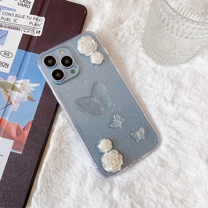 Détail de la coque iPhone pailletée bleu clair avec roses en résine et papillons