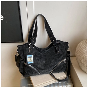 Detail view of black matte leather tote bag with silver hardware and card holder charm