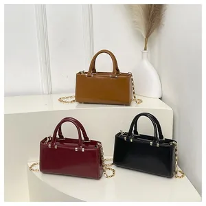 Detailed display of tote bags in brown, burgundy and black with gold chains