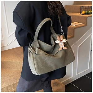 Detail of olive green tote bag featuring high-quality faux leather and plush bunny charm
