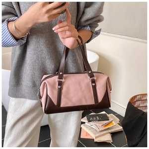 Detail of pink canvas and brown leather Boston bag with zip closure and double handles
