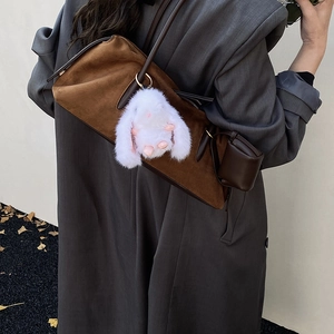 Schicker weißer Plüschhase Anhänger mit rosa Details an einer braunen Wildledertasche