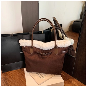 Détail d'un sac cabas en daim marron avec bordure en fausse fourrure blanche et lanière