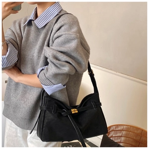 Close-up of minimalist black matte tote bag with elegant gold square buckle detail