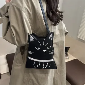 Détail du sac bandoulière chat mignon avec broderie blanche sur similicuir noir