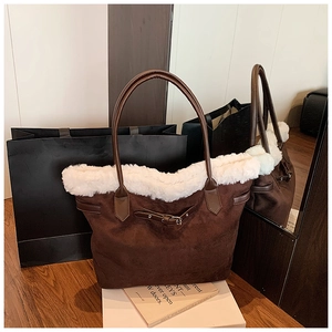 Gros plan du sac cabas en daim marron avec bordure en fausse fourrure et lanière cuir