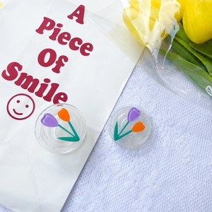 Flat round clear contact lens case with purple and orange tulip floral patterns