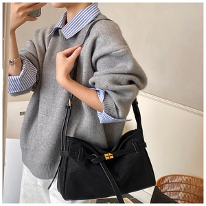 Detail shot of the suede black hobo bag showing the elegant golden metal twist lock closure