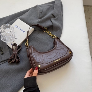 Dark brown crescent shoulder bag in wrinkled leather with gold chain and crossbody strap
