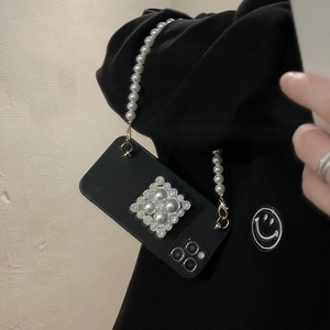 Detailed close-up of a black iPhone case featuring a square pearl buckle and pearl chain