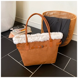 Détail d'un sac cabas en daim marron avec bordure en peluche blanche et bride en cuir