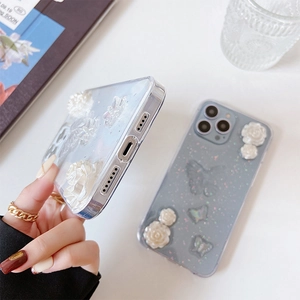Détail de coque iPhone pailletée avec roses 3D et décorations de papillons laser