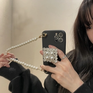 Detail of iPhone case with pearl hand strap and vintage crystal grip on mirror selfie