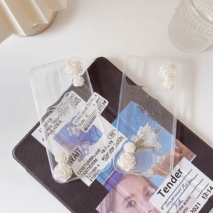 Détail de coque iPhone transparente avec roses blanches 3D et papillon élégant