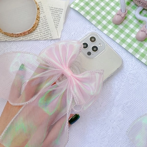 Close-up of laser pink ribbon bow phone stand on clear case with iridescent metallic gloss
