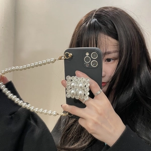 Detail of black iPhone case with luxury pearl handbag strap and sparkling crystal stand