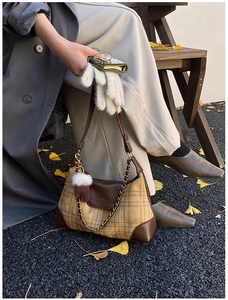 Detailed view of vintage plaid shoulder bag with leather trim and gold chain detail