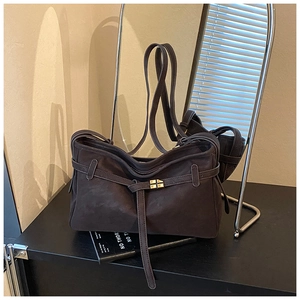 Close-up of deep brown matte leather tote with gold rectangular turn-lock buckle