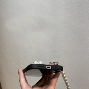Detail of iPhone case with pearl strap showing precise bottom charging port cutouts