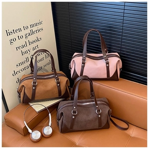 Detail view of multi-color suede boston bags with dual handles and adjustable straps