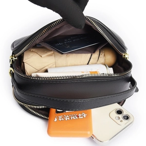 Top-down view of black leather crossbody bag showing spacious interior with multi-compartments