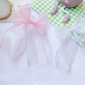 Macro detail of oversized lace bow phone grip with iridescent pink and white organza