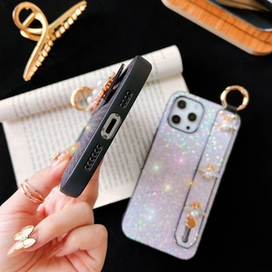 Detail of glitter iPhone case featuring a stylish handle strap and pearl bee charms