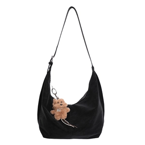 Black crescent dumpling bag in matte faux leather with cute brown bear charm