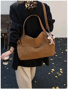 Detail of a brown large-capacity tote bag with a cute bunny charm and adjustable strap