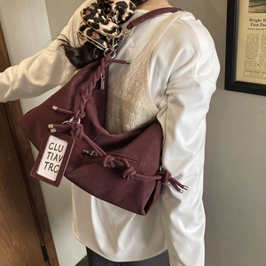 Winter vintage burgundy hobo bag with woven strap and matte leather texture on shoulder