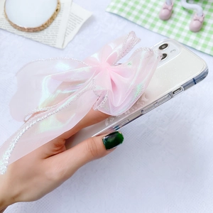 Macro detail of large pink organza lace bow on glitter white phone case accessory