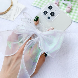 Detail of white iridescent lace bow phone socket on transparent case with silver edge