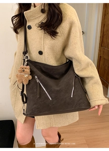 Detail of retro coffee brown tote with silver zippers and a cute plush bear charm