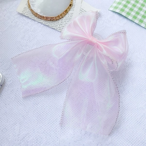Macro detail of pink organza laser bow hairclip with iridescent finish and silver edge