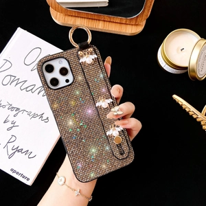 Detail of luxury iPhone case with glitter sequins, metal bee, and pearl wrist strap