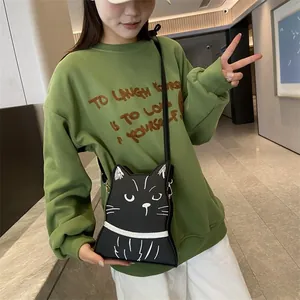 Détail d'un sac à bandoulière chat noir avec broderie porté par un mannequin féminin