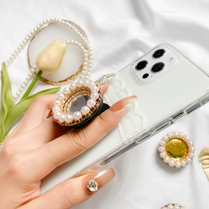 Close-up of elegant white glitter phone case with pearl-rimmed socket on silk background