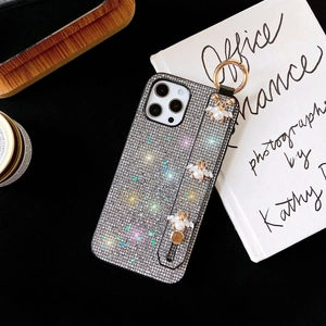 Close-up of glitter iPhone case featuring pearl bee pendants and silver rhinestone texture