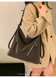 Close-up of minimalist dark grey tote bag with silver zippers and adjustable strap