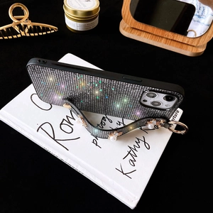 Close-up of iPhone glitter case with silver grid pattern and white pearl wrist strap
