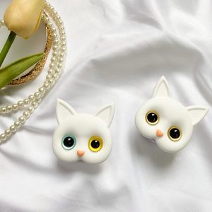 Detailed view of two white cat phone grips on silk with pearls and yellow tulips