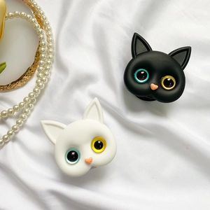 Detail of cute cat phone grips with heterochromia eyes on white satin fabric