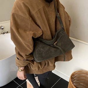 Minimalist dark gray tote bag with matte texture and side strap shown on model's shoulder