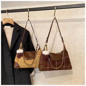 Detail of vintage plaid shoulder bags in khaki and brown with metal chain and plush charms