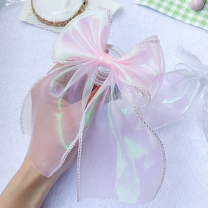 Detail shot of a pink laser organza ribbon phone grip with delicate silver edge stitching