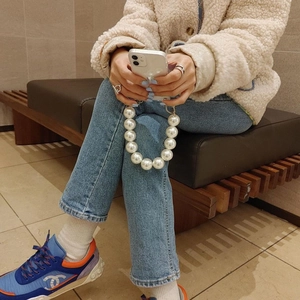 Detailed view of luxury pearl wrist strap for iPhone case with large 12mm white beads
