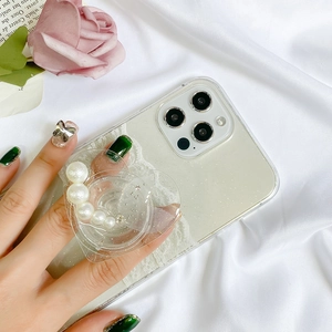 Detail of glitter iPhone case with heart-shaped pearl phone grip and white lace edge