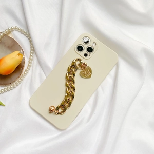 Detailed view of cream white iPhone case with a thick gold chain and heart pendant