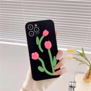 Detail view of 3D pink tulip flower relief on a black iPhone case held by a person
