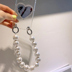 Detail of transparent phone case with heart mirror and elegant pearl bead hand strap